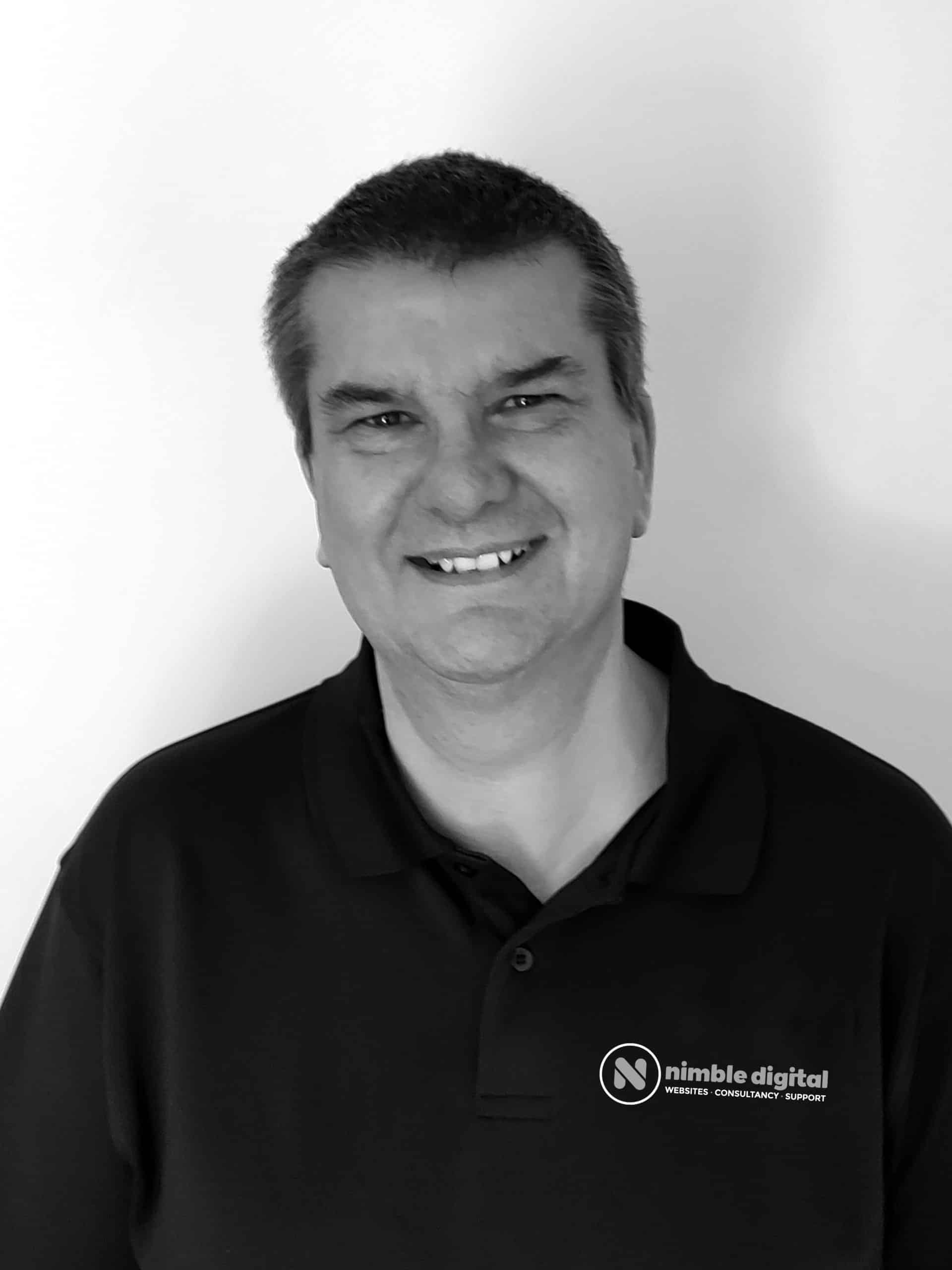 A black and white photo of Gordon Sheppard in a polo shirt.